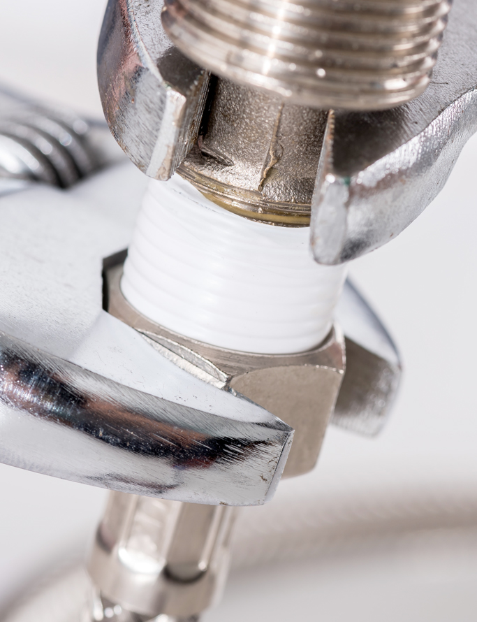Close-up of a wrench tightening a plumbing fitting